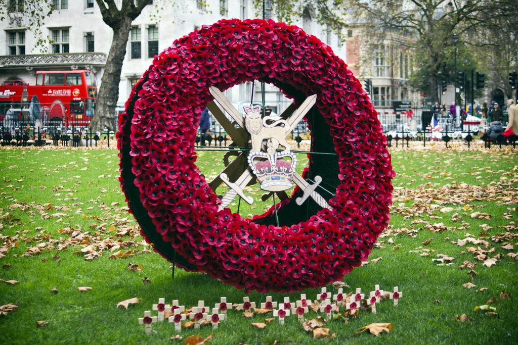 London, England - November 13, 2015: A group of memorial crosses and a large memorial wreath at the Field of Remembrance at Westminster Abbey, London. Each cross carries an English memorial poppy, the symbol of the Royal British Legion. A sprinkling of autumn leaves adds a poignant reminder of ‘the fallen’. © Linda Steward