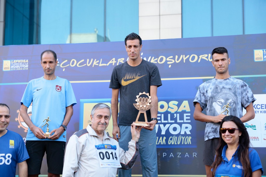President Akıncı presents Serdar Çetin, the winner of the Lefkoşa Marathon men's race, with his trophy